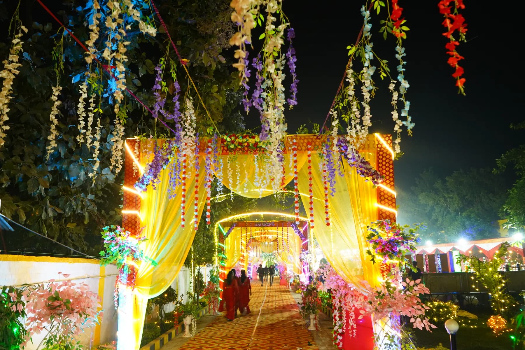 Floral entrance walkway with hanging flowers and lights