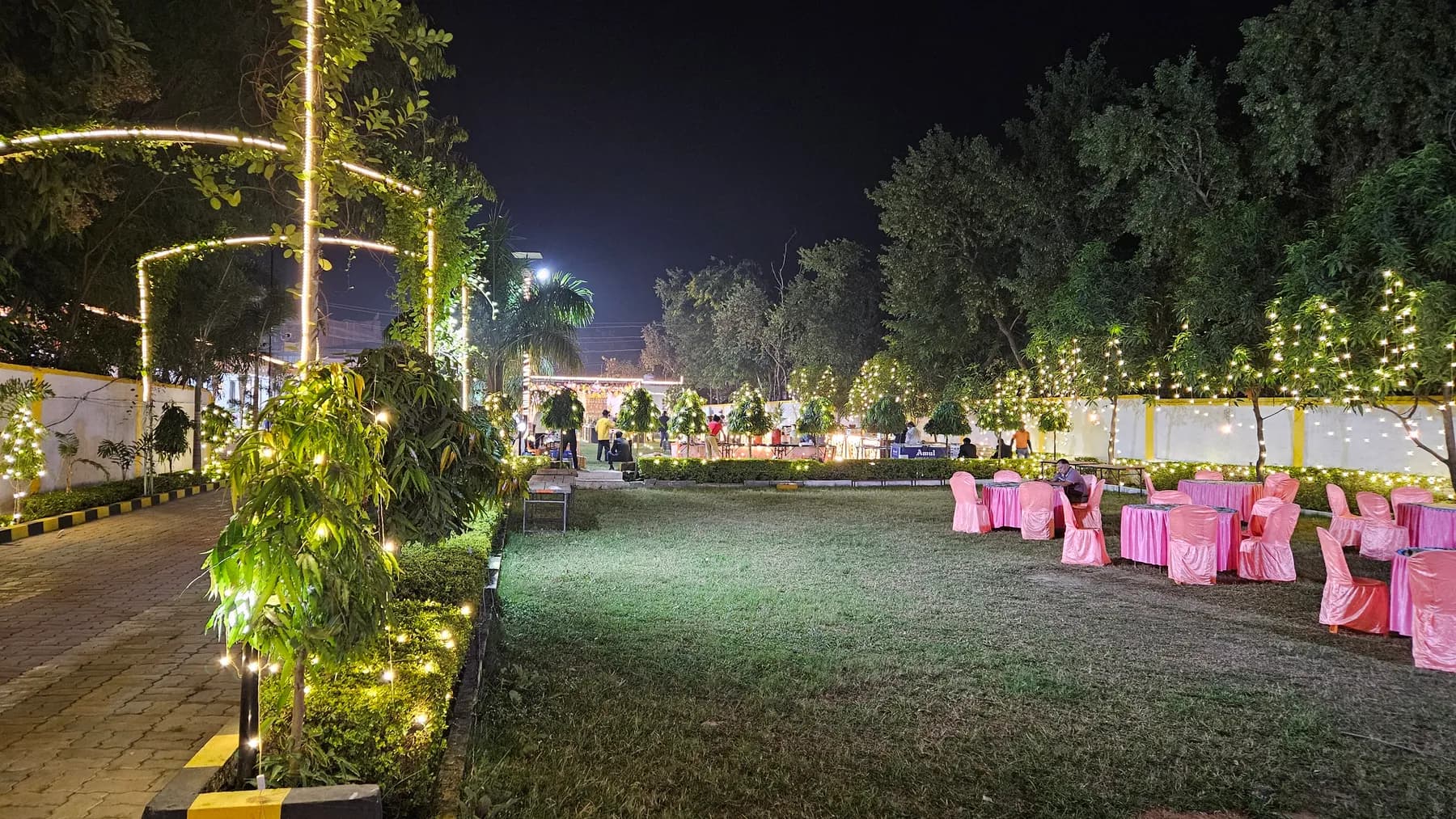 Garden lawn with fairy-lit trees at Bandhan Marriage Hall